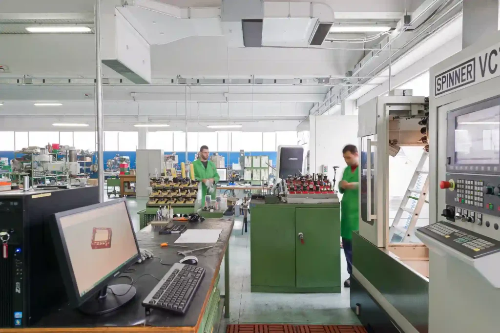 Tecnici MECWORK al lavoro tra progettazione CAD e lavorazioni meccaniche CNC nel reparto produttivo