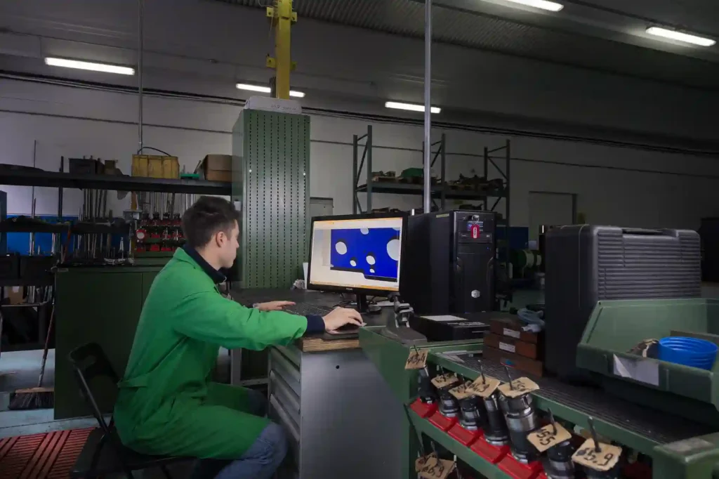 Tecnico MECWORK impegnato nella programmazione e gestione di lavorazioni meccaniche di precisione per componenti industriali realizzati su disegno